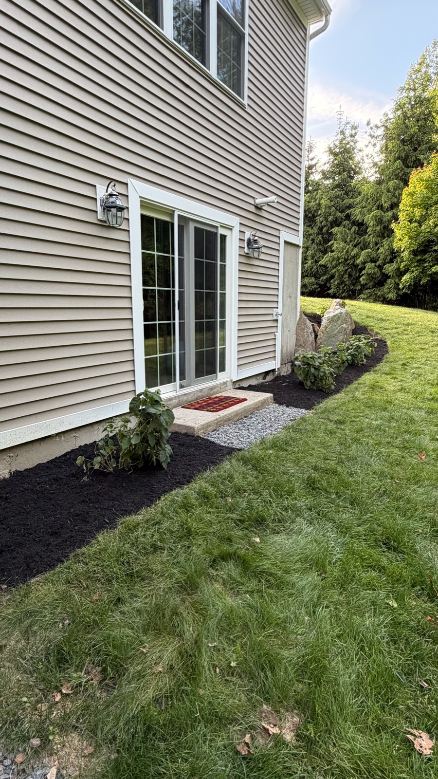 Finished planting bed with fresh dark mulch along a Hopkinton-area home