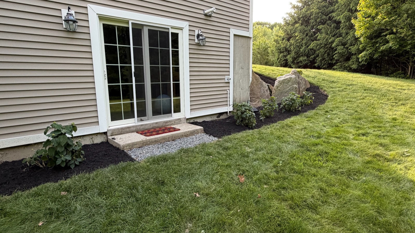 After: finished mulch beds with plantings, stone step and gravel